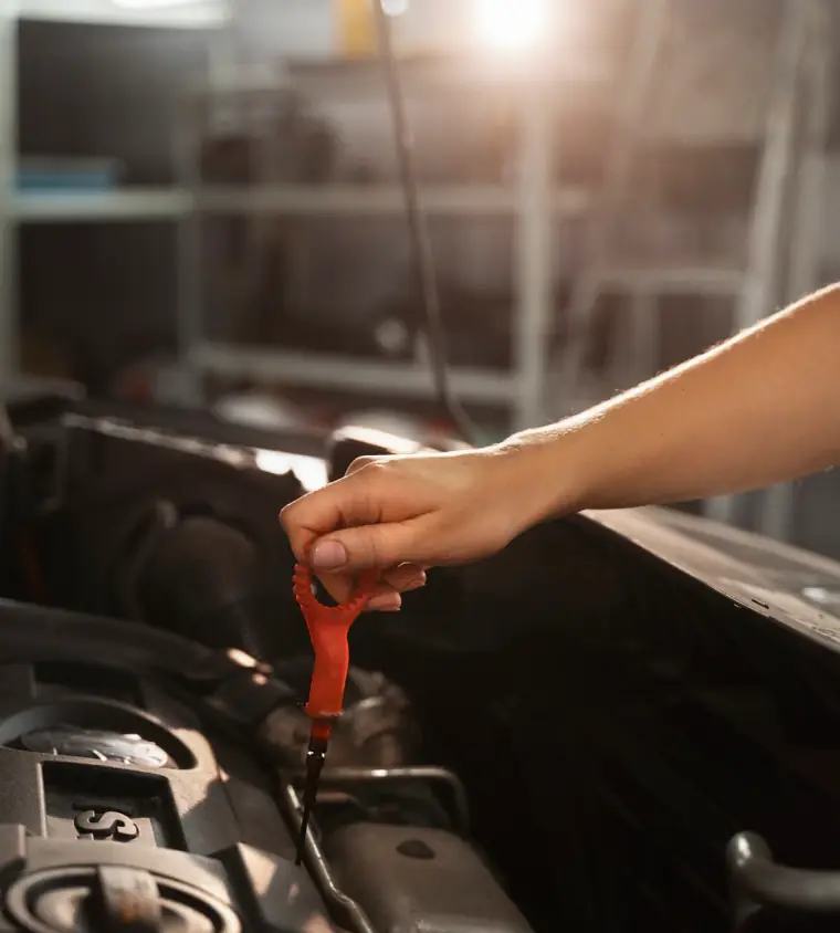Rafael Santana checking engine oil during a mobile auto service call in Jacksonville, FL